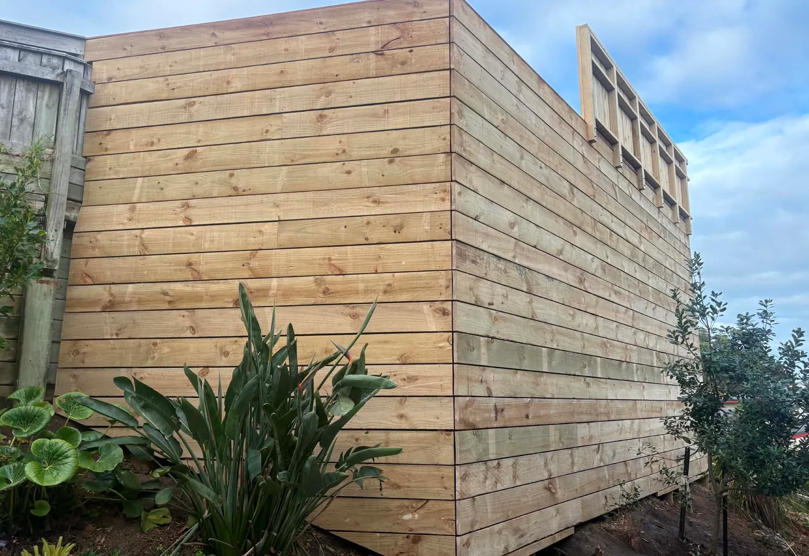 The horizontal timber privacy screen behind the deck, tying the structure into the property